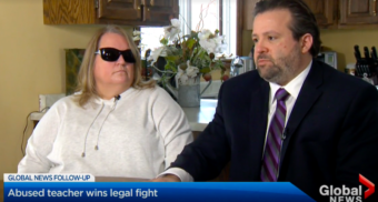 Julie Austin, teacher in the Simcoe Muskoka Catholic District School Board, sits next to her disability lawyer, James K. Fireman, at her kitchen table while wearing sunglasses as she shares her story with Global News.