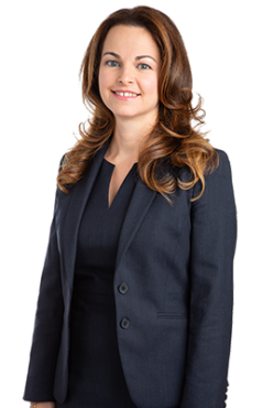 A photo of besuited disability lawyer Tamar Agopian, shot from the waist up.