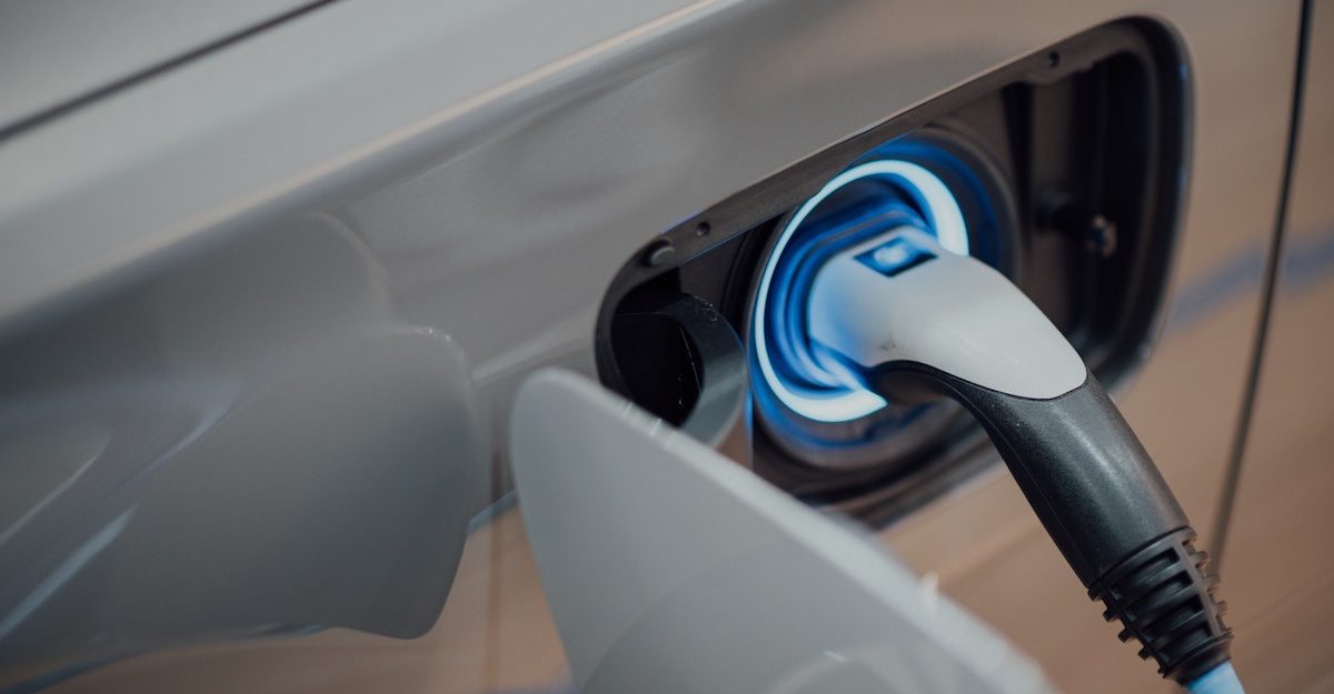 A glowing charging socket is plugged into an electric vehicle. VinFast LLC employees are entitled to severance when they lose their job.