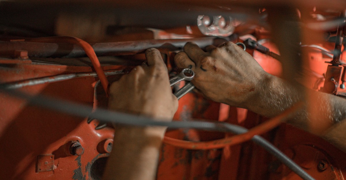 A photo of a person working on a red machine. (Photo: Nina Mercado / Unsplash)