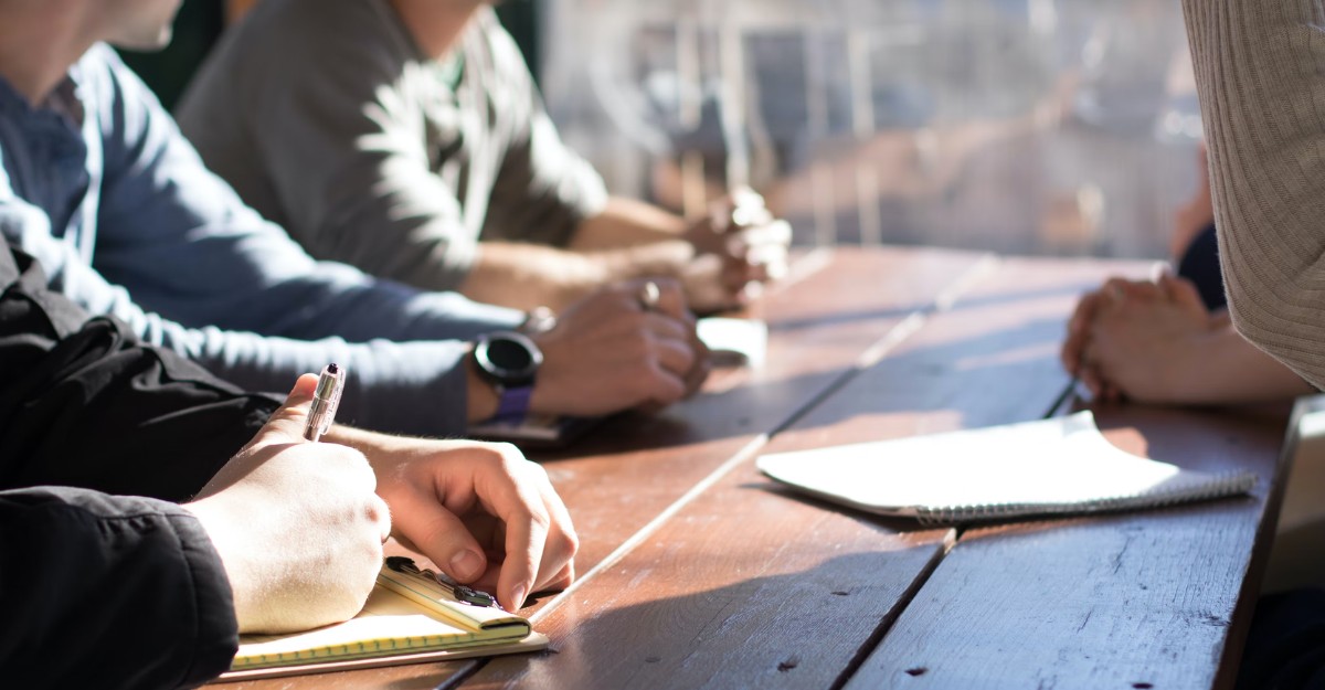 A photo of staff attending a meeting and taking notes. (Photo: Dylan Gillis / Unsplash)