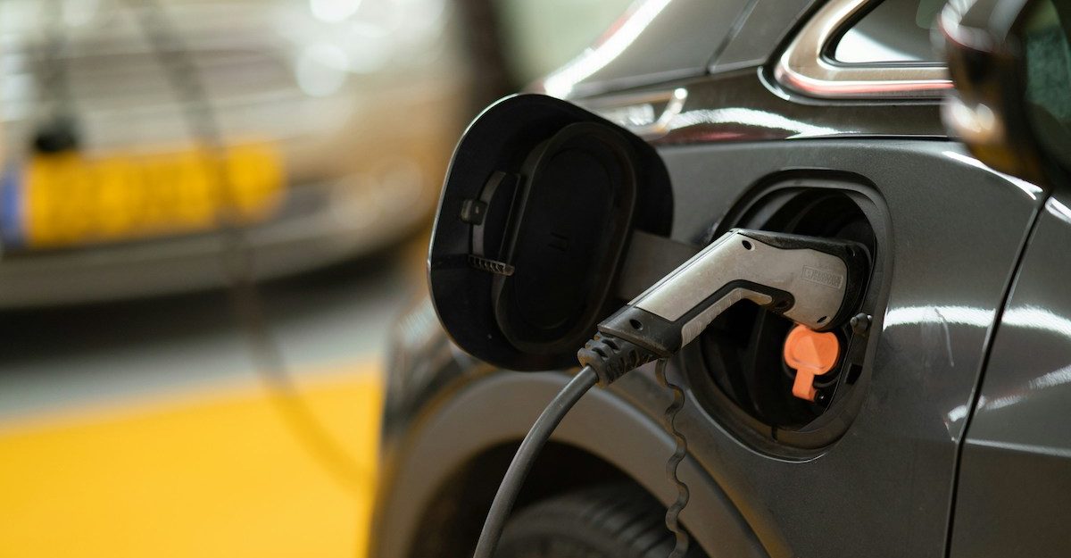 An electric vehicle, potentially a Rivian product, is seen charging.