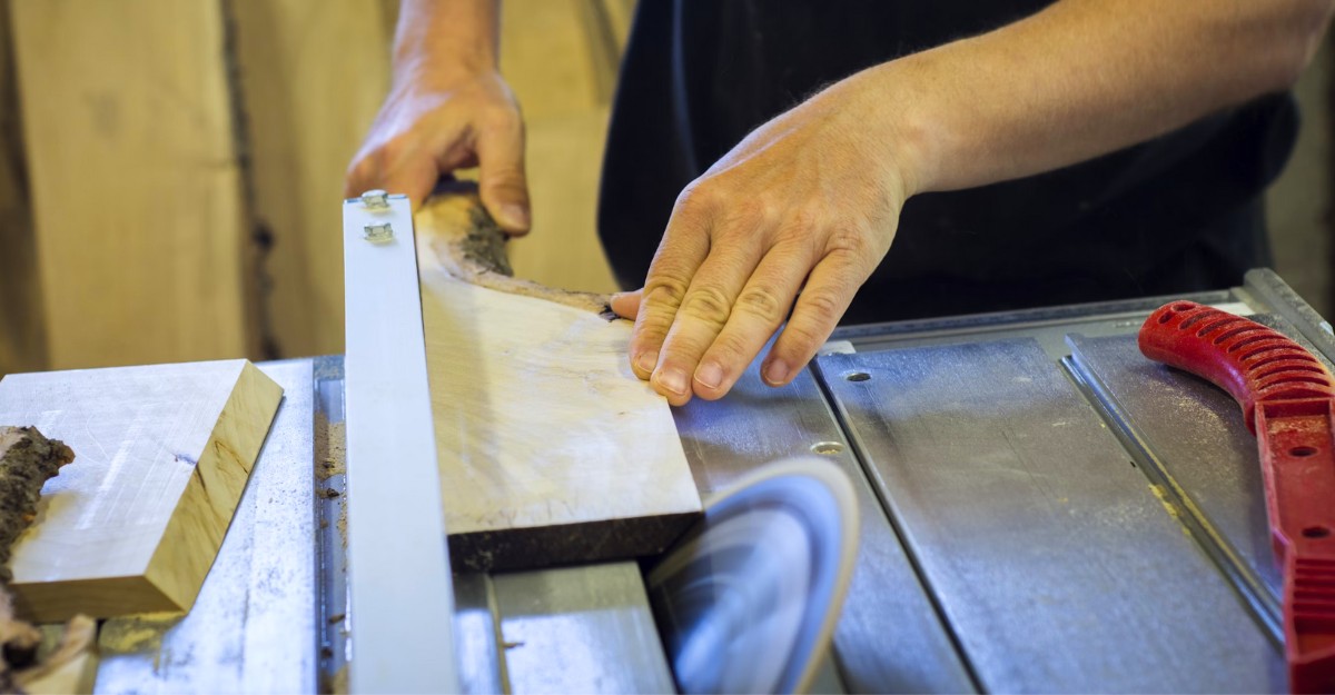 A photo of a person cutting a piece of wood with a saw. (Photo: Blaz Erzetic / Unsplash)