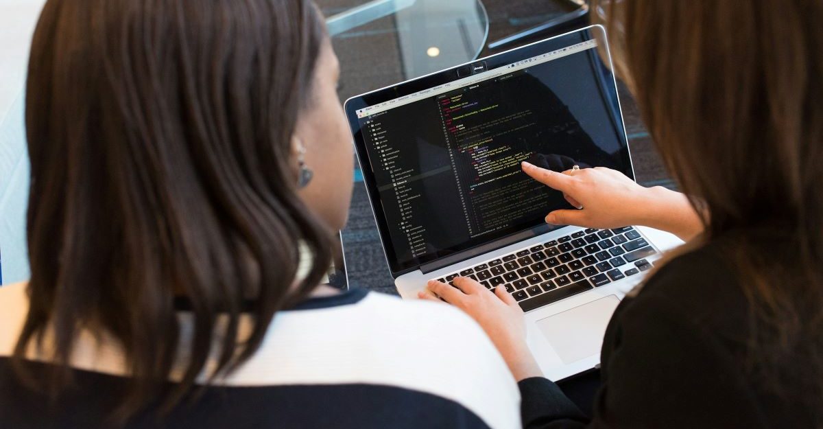 An IT trainer, similar to those at Calian, shows a client how to work with code.