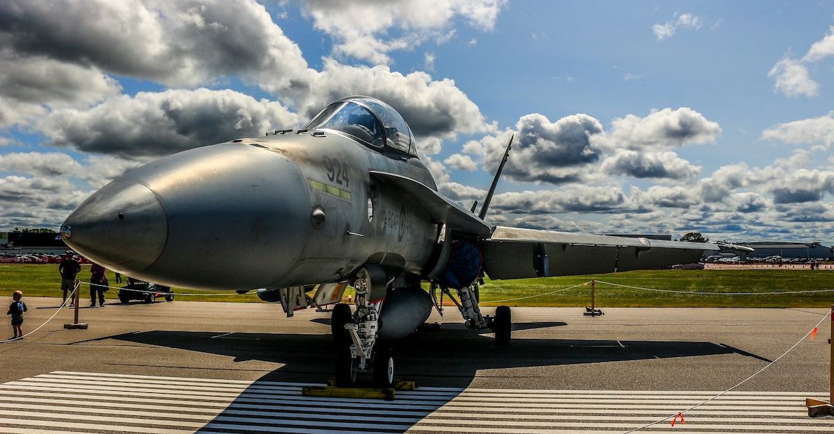 A fighter jet is shown, potentially maintained by L3Harris.