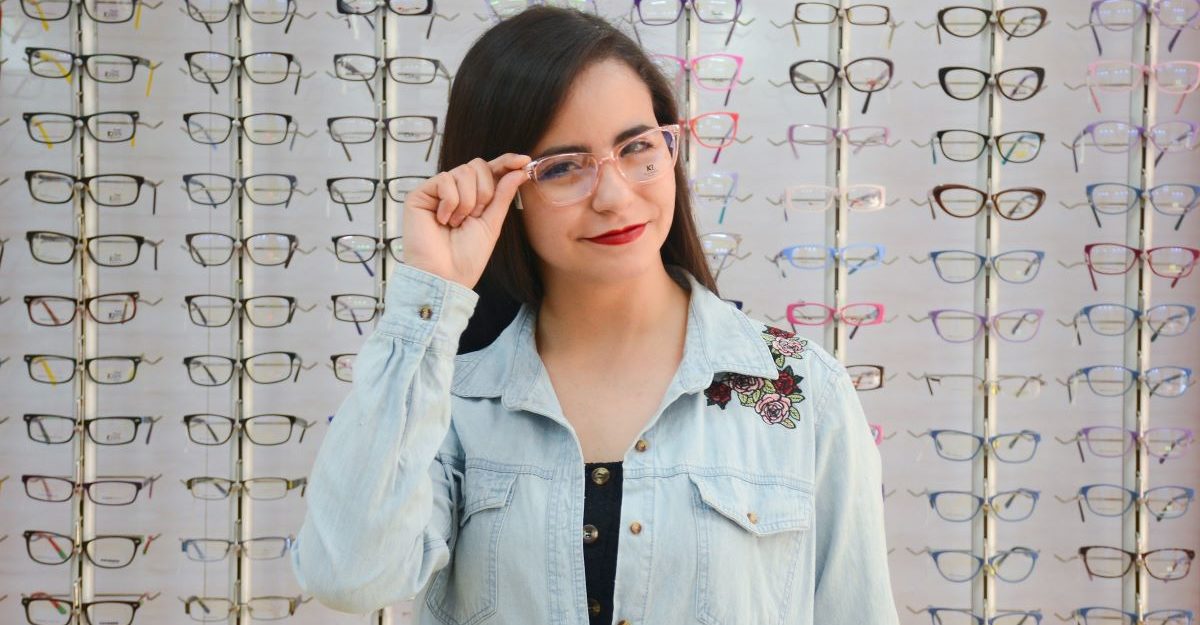 A woman tries on a pair of glasses, potentially in an FYidoctors location.