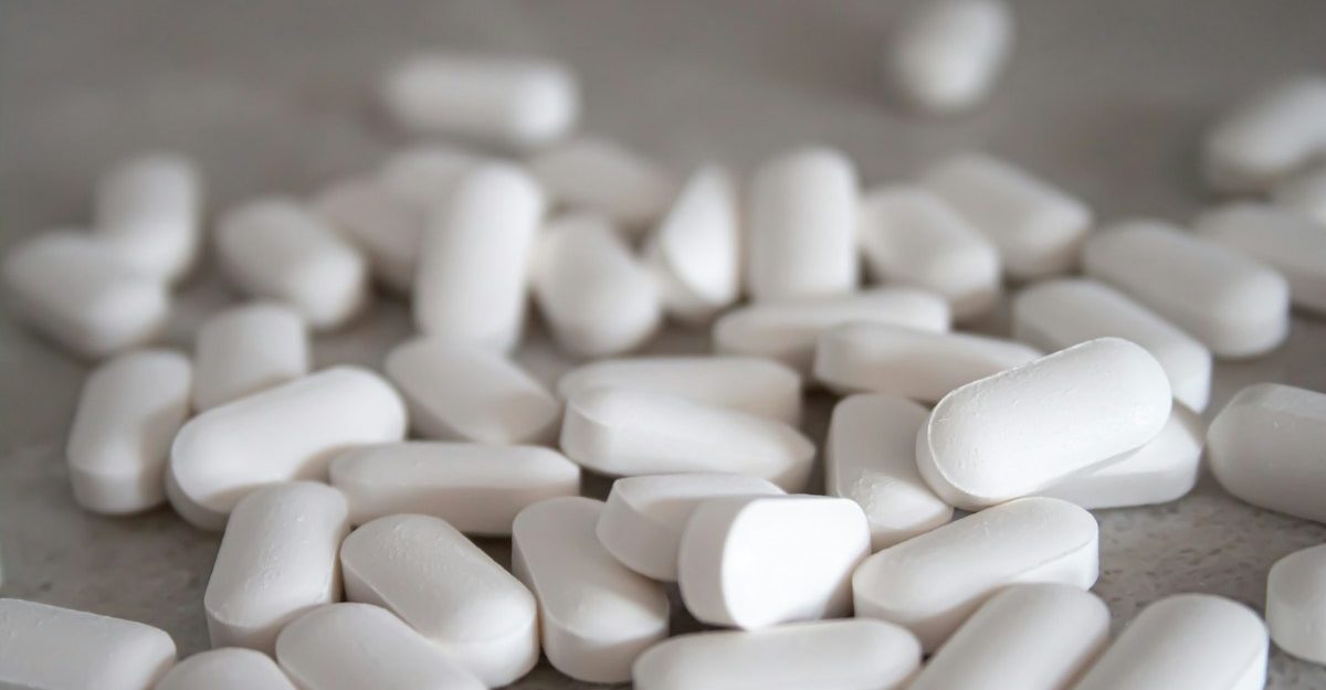 A collection of white pills, potentially manufactured by Kenvue.