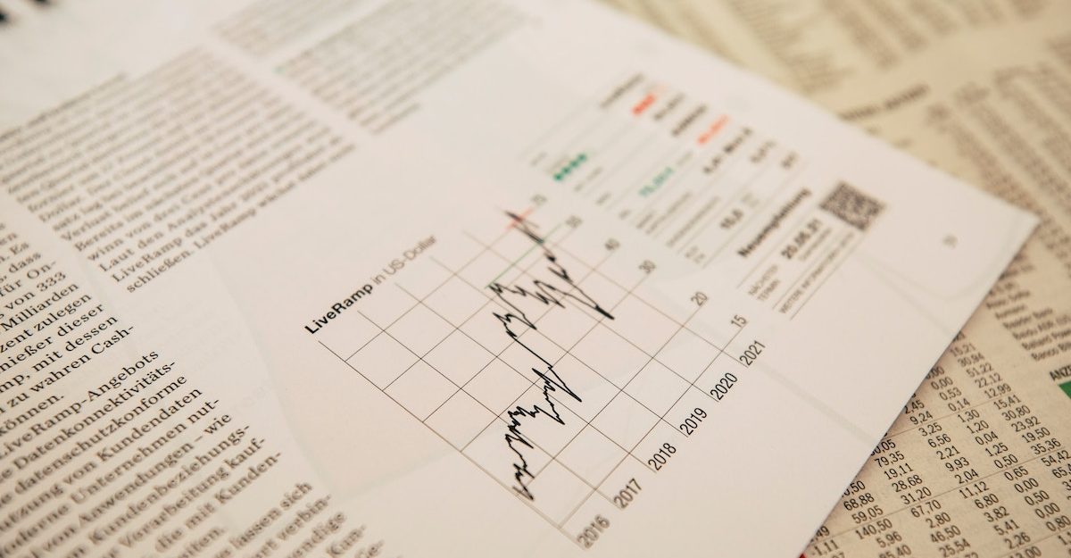 A sheet displaying financial information, possibly for Apex Group, sits on top of the stock section of a newspaper.