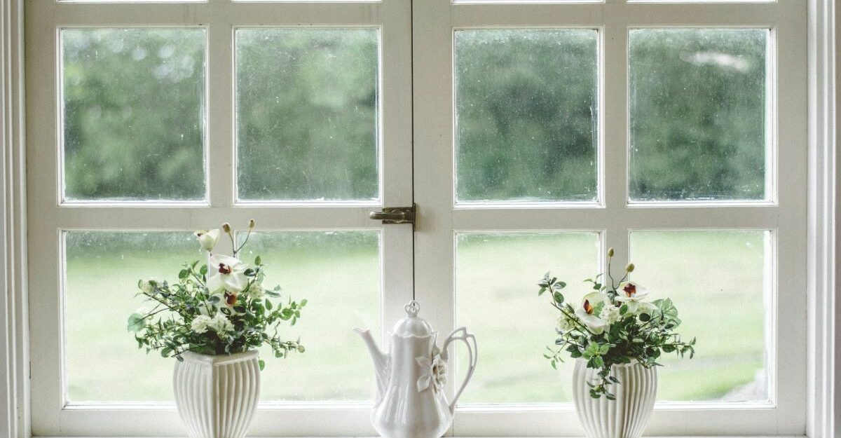 Vases and a teapot sit on a window sill.