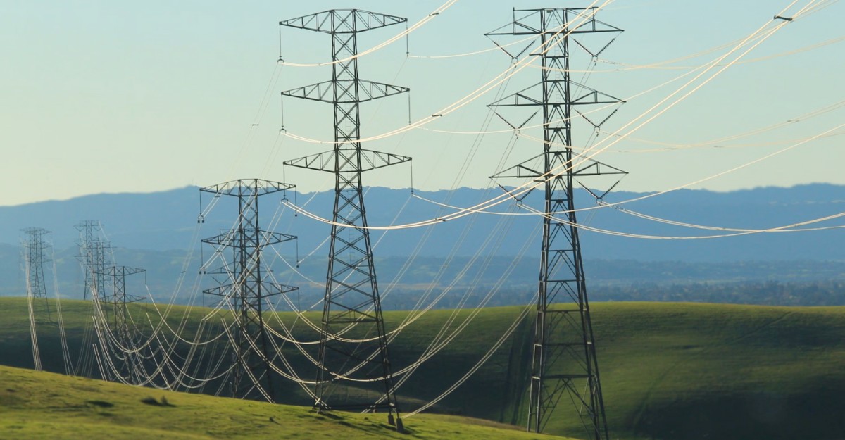 A photo of power lines across a green field. (Photo: Annabella Parrales / Unsplash)