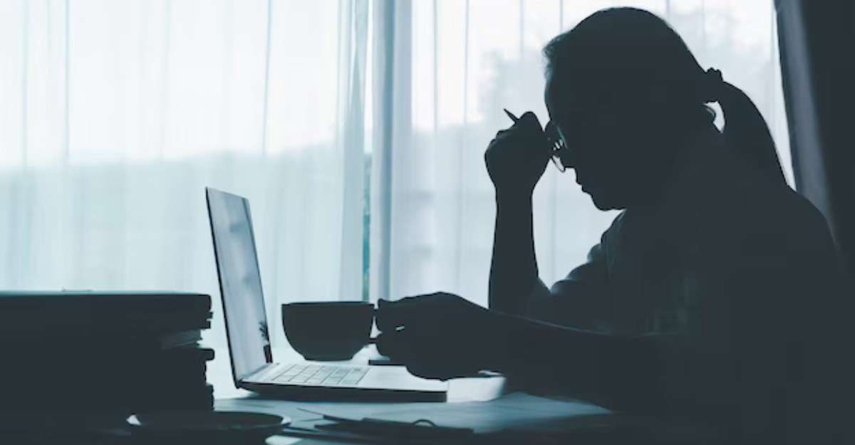 A photo of a person rubbing their forehead while staring at a laptop. (Photo: dapor2560 / Freepik)