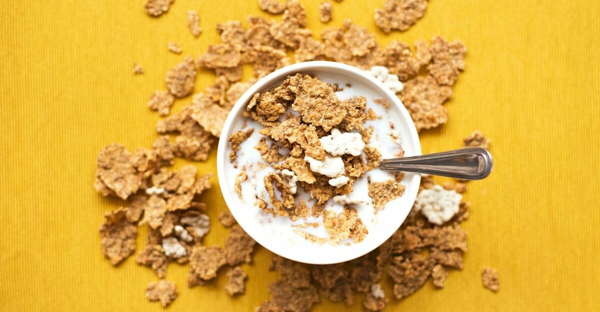 A bowl haphazardly filled with cereal and milk.