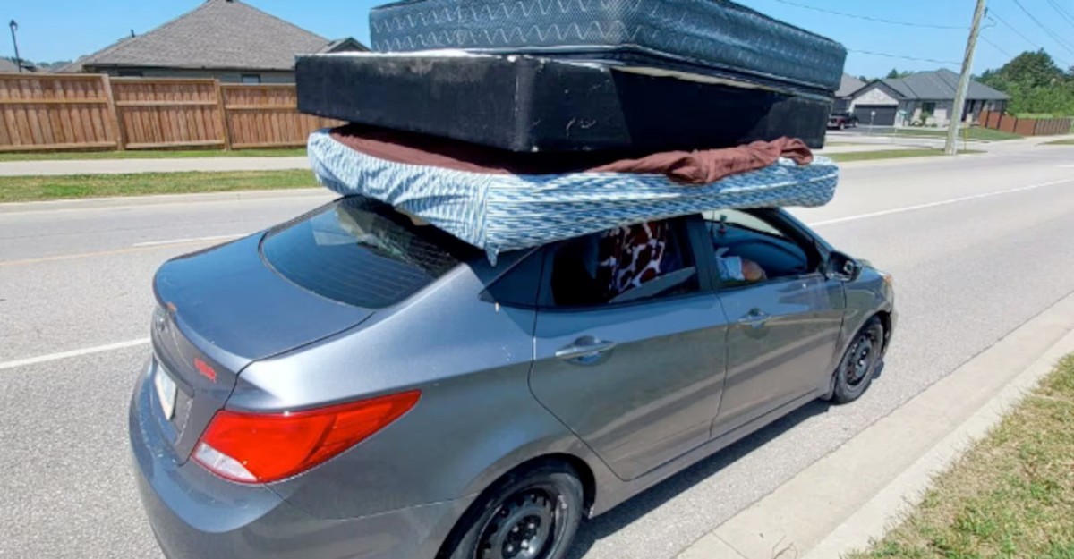A photo of a grey Hyundai Accent with unsecured mattresses on the roof stopped by police in Paris, Ontario. (Photo: OPP)