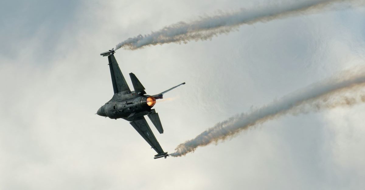 A close up shot of a fighter jet, potentially in use by CAE, streaking across the sky.