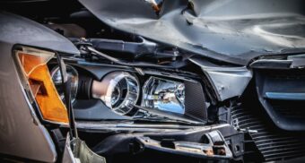 A close-up of a vehicle's damaged headlight and hood following an Oshawa car crash.