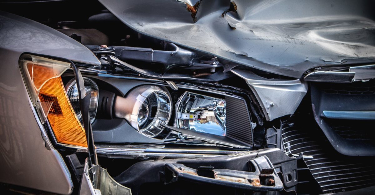 A close-up of a vehicle's damaged headlight and hood following an Oshawa car crash.