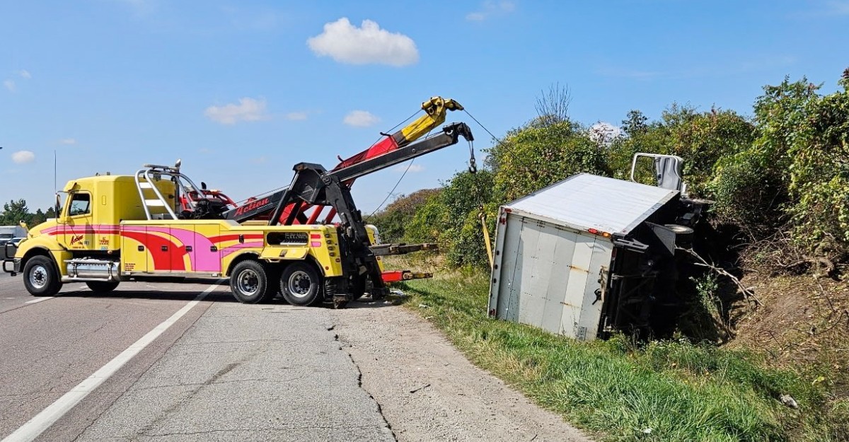 A photo of a tow truck removing a commerical vehicle from a ditch on Highway 401, south of Guelph. (Photo: OPP_HSD / X/Twitter)