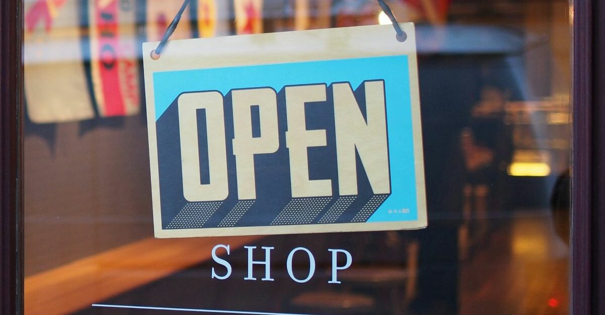 An open sign is seen in a store window.