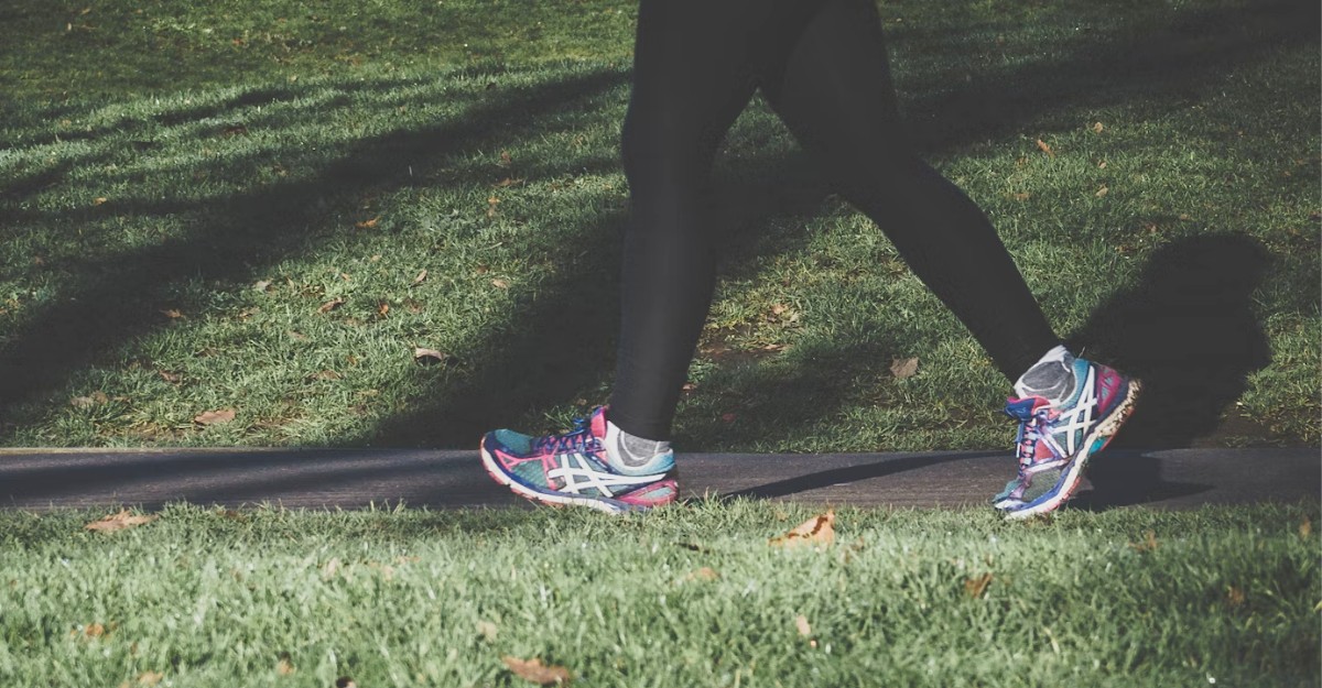 A woman with running shoes on walks through a public park. (Photo: Areksan / Unsplash)