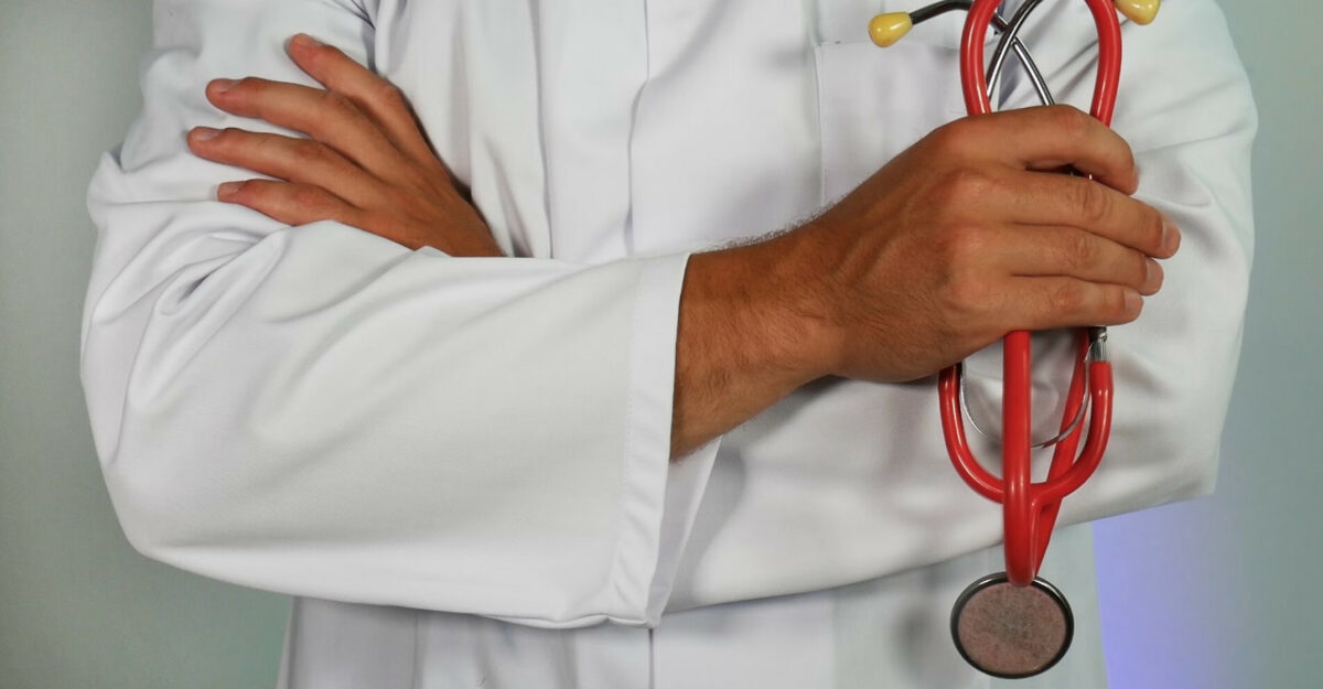 A doctor holding a red stethoscope. (Photo: impulsq / Unsplash)