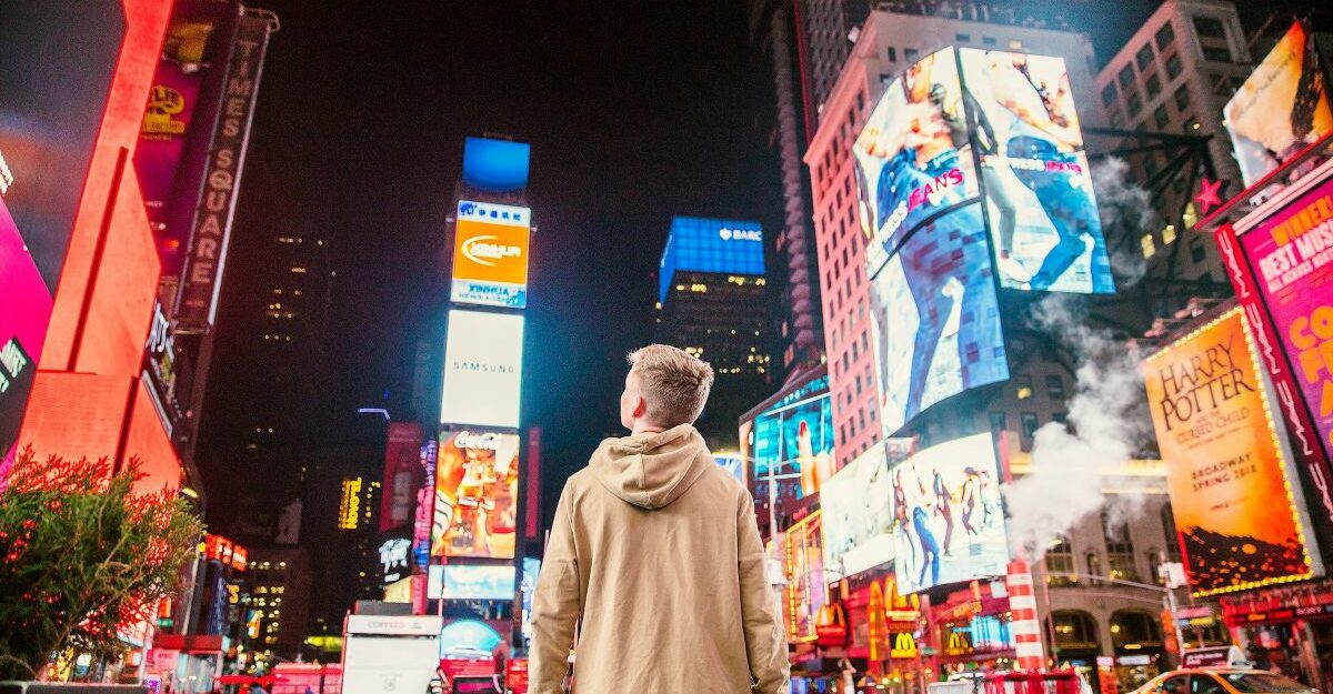 A young man gazes at the numerous digital advertisements in Times Square.