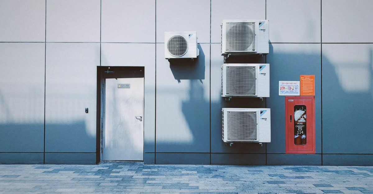Air conditioners sit on the side of a building to cool and ventilate the interior.