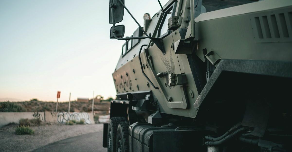 A view of the right side of a new armoured vehicle as it motors down a road.