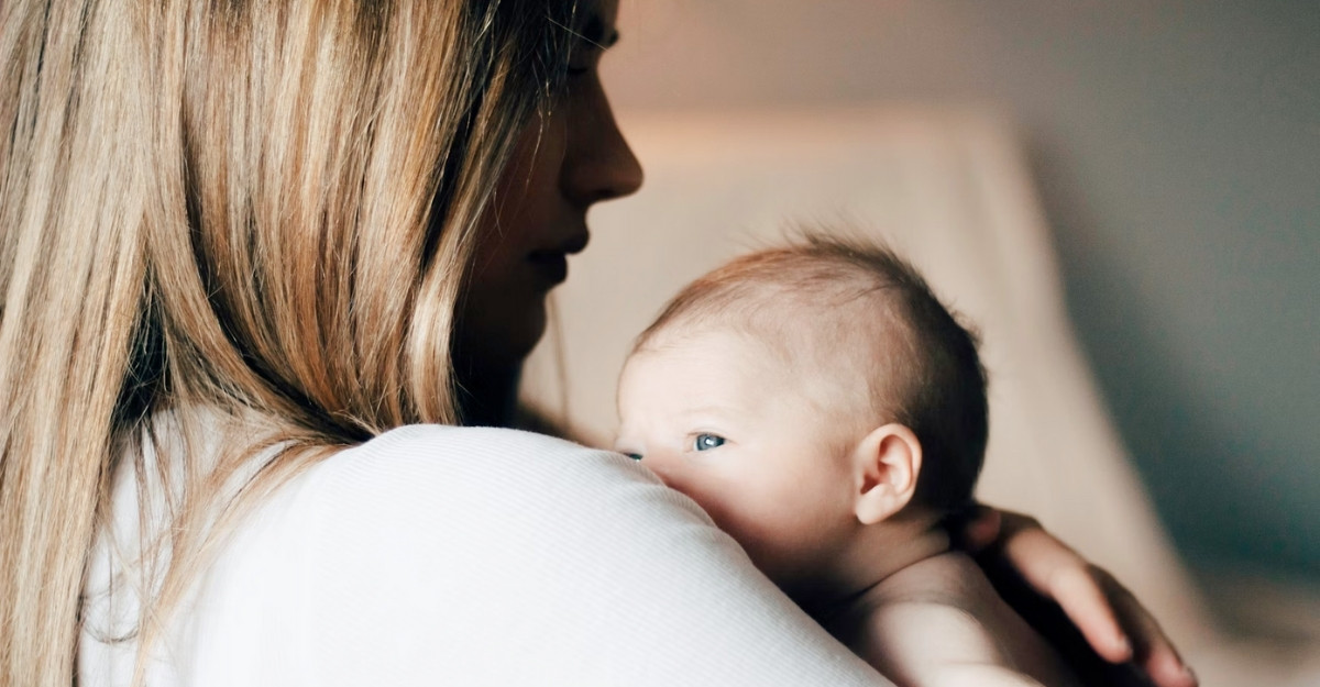 A mother holding her newborn baby. (Photo: Hollie Santos / Unsplash)