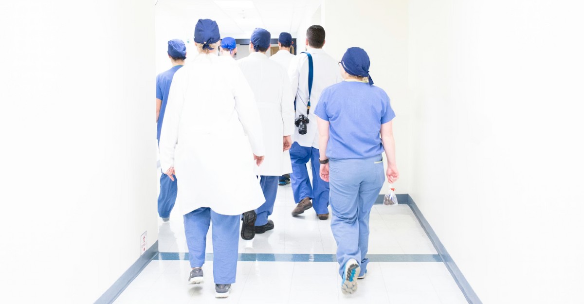 A group of nurses walking down a hallway in a hospital. (Photo: Luis Melendez / Unsplash)