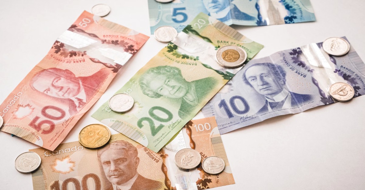 Canadian currency on a table. (Photo: PiggyBank / Unsplash)