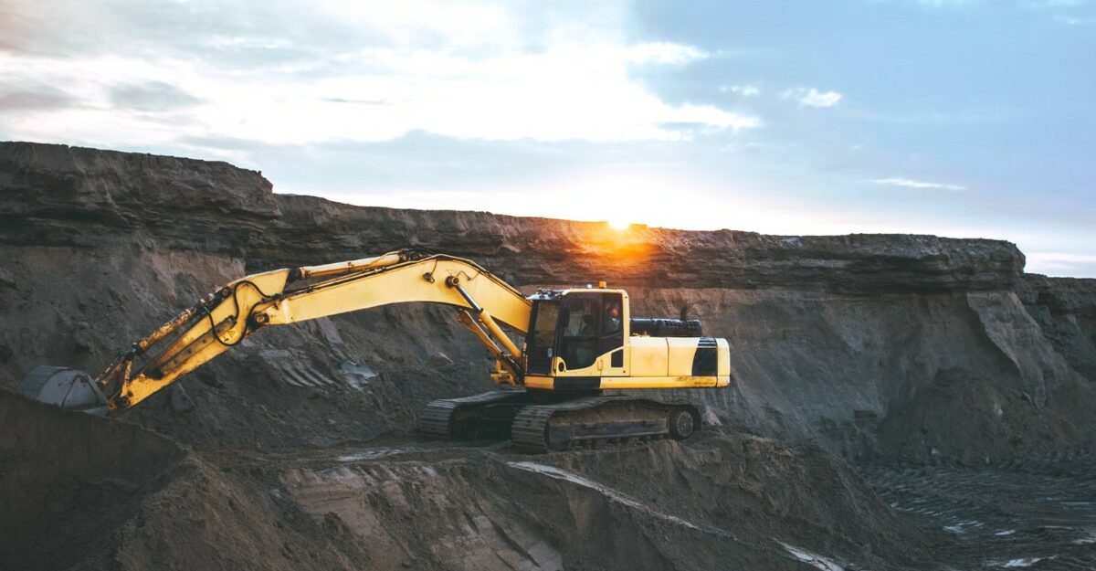 An excavator on the side of a cliff. (Photo: Artyom Korshunov / Unsplash)
