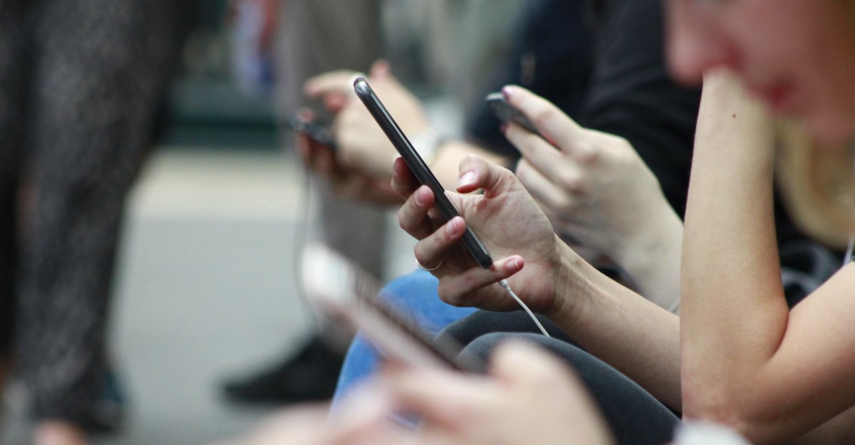 People interacting with their phones. (Photo: ROBIN WORRALL / Unsplash)