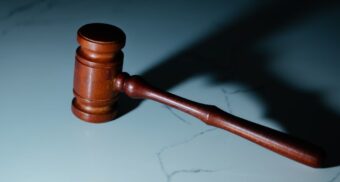 A wooden gavel on a marble table. (Photo: Wesley Tingey / Unsplash)