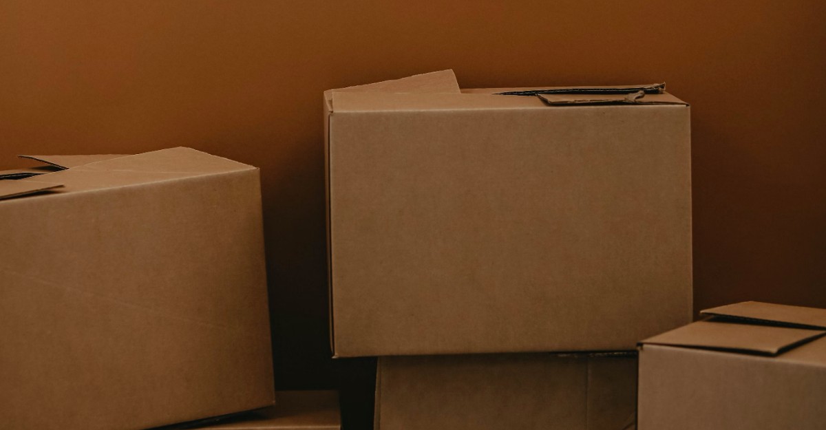 Cardboard boxes against a brown wall. (Photo: Kadarius Seegars / Unsplash)